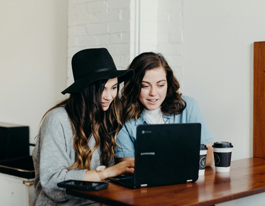 Dos asistentes trabajan juntas en una laptop